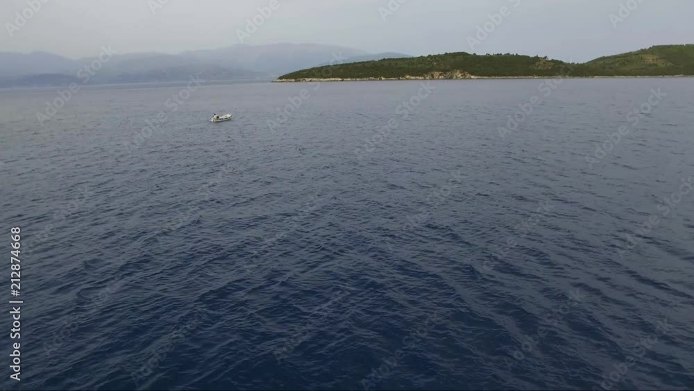 Aerial shot over the sea. Fishing boat in the horizon. Travel across islands. Aerial shot over the sea. Fishing boat in the horizon. Travel across islands.