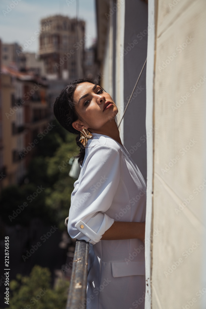 Portrait of young woman leaning on railing on balcony Portrait of young woman leaning on railing on balcony