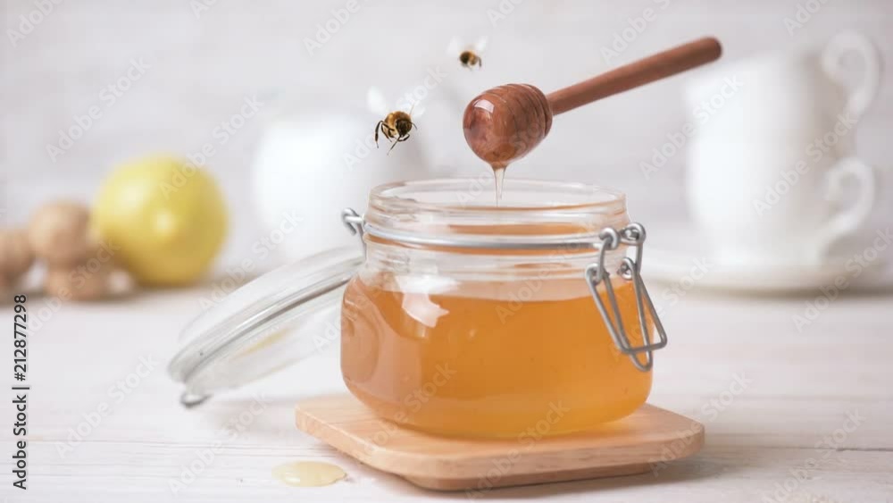 Cinemagraph - Honey pouring in jar. Bee flying . Living Photo. Cinemagraph - Honey pouring in jar. Bee flying . Living Photo.