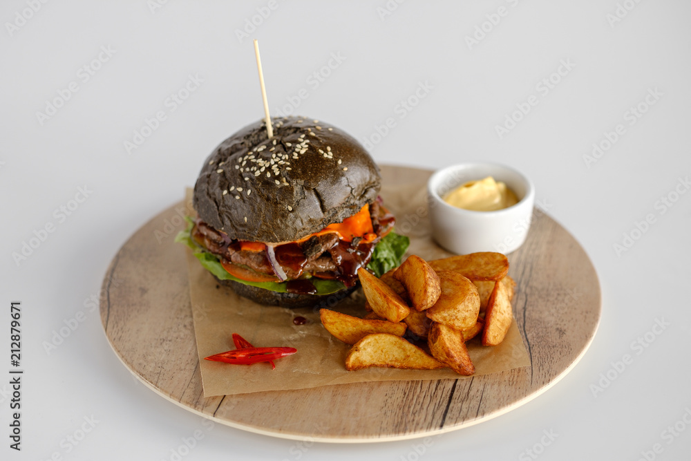 burger with potato wedges on a wooden tray