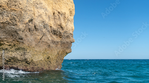 The iconic natural rock formation called The face in Praia da Marinha in Algarve, Portugal photo