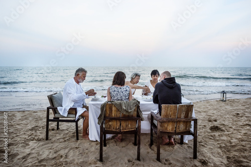 Mature friends having a dinner party at the beach © Rawpixel.com