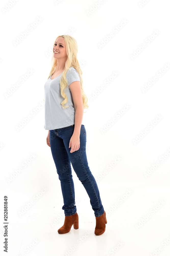 full length portrait of blonde girl wearing simple blue shirt and jeans, standing pose. isolated on white background. full length portrait of blonde girl wearing simple blue shirt and jeans, standing pose. isolated on white background.