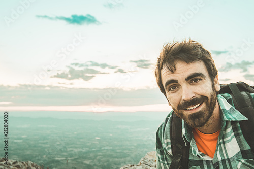 Guy with a beard smiling in the mountains .Man looked at the camera and smiled