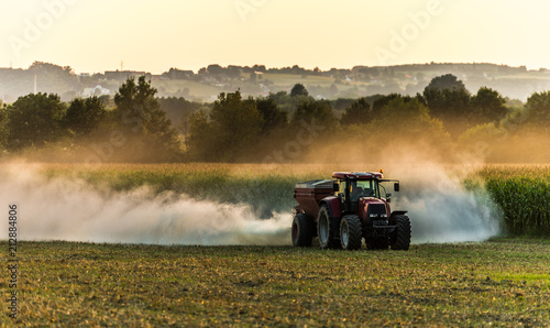 Traktor am feld sonnenuntergang düngen photo