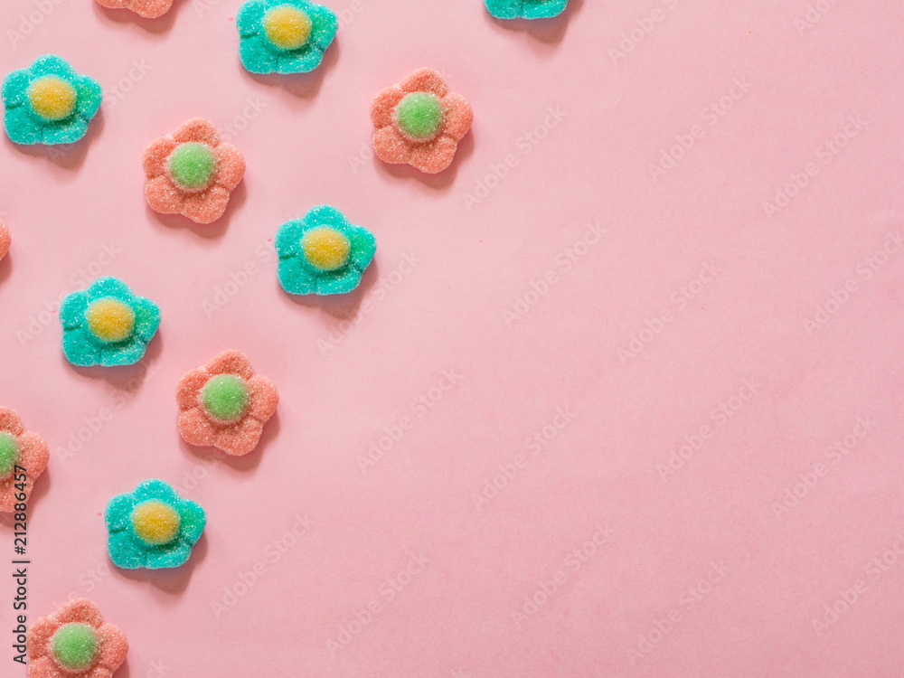 Pink and blue flower jelly candies pattern on pink background with copy space