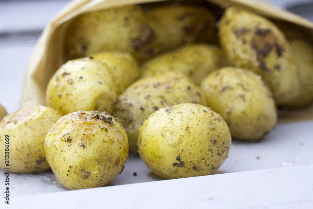 Roasted potatoes with herbs in paper bag 