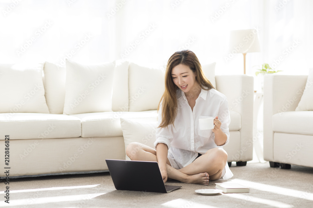 Cheerful young Chinese woman using laptop at home Cheerful young Chinese woman using laptop at home