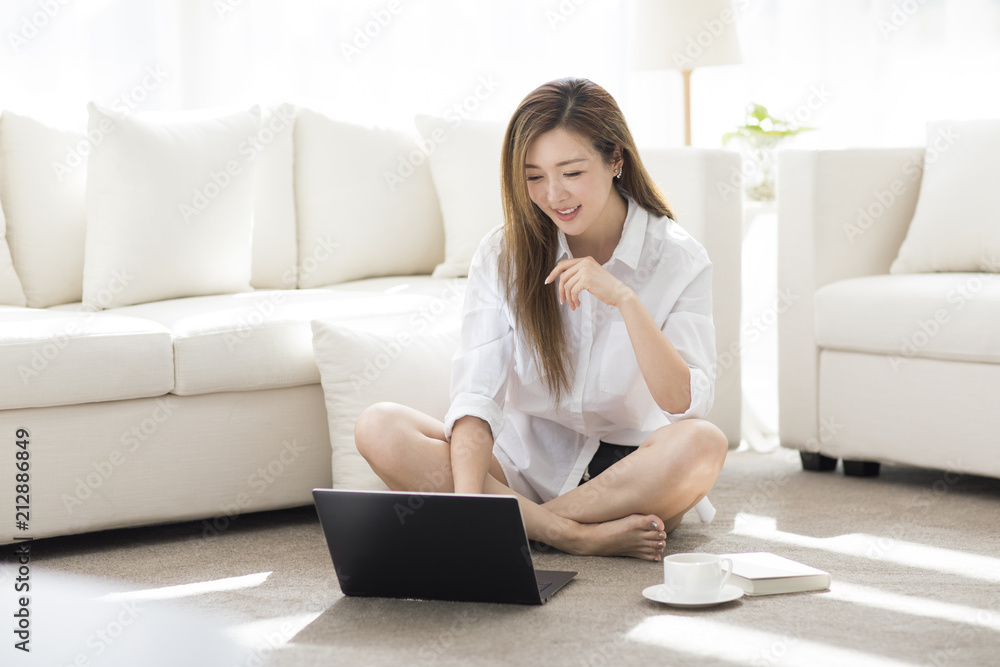 Cheerful young Chinese woman using laptop at home Cheerful young Chinese woman using laptop at home