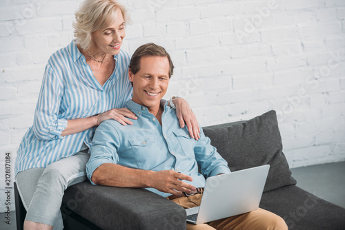 high angle view of smiling senior couple using laptop together