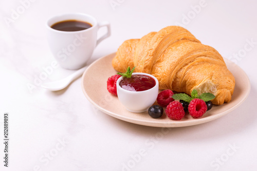 Fototapeta Naklejka Na Ścianę i Meble -  Coffee, fresh croissant with jam and berries for breakfast
