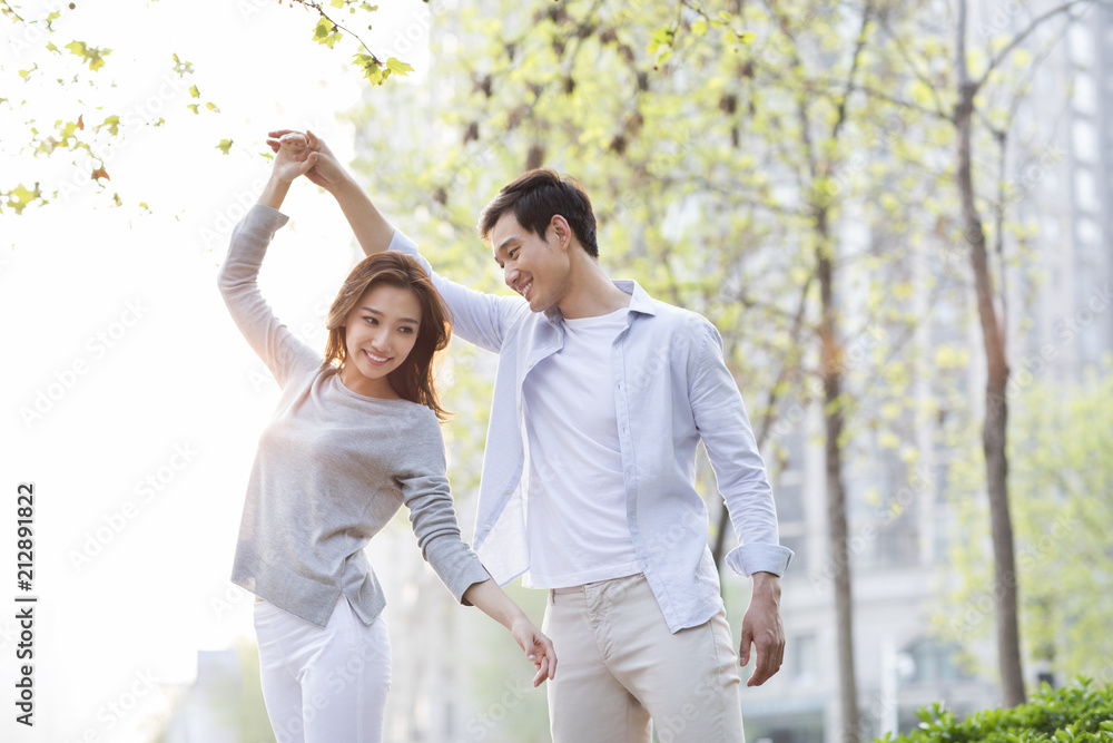 Happy young Chinese couple dancing outdoors Happy young Chinese couple dancing outdoors