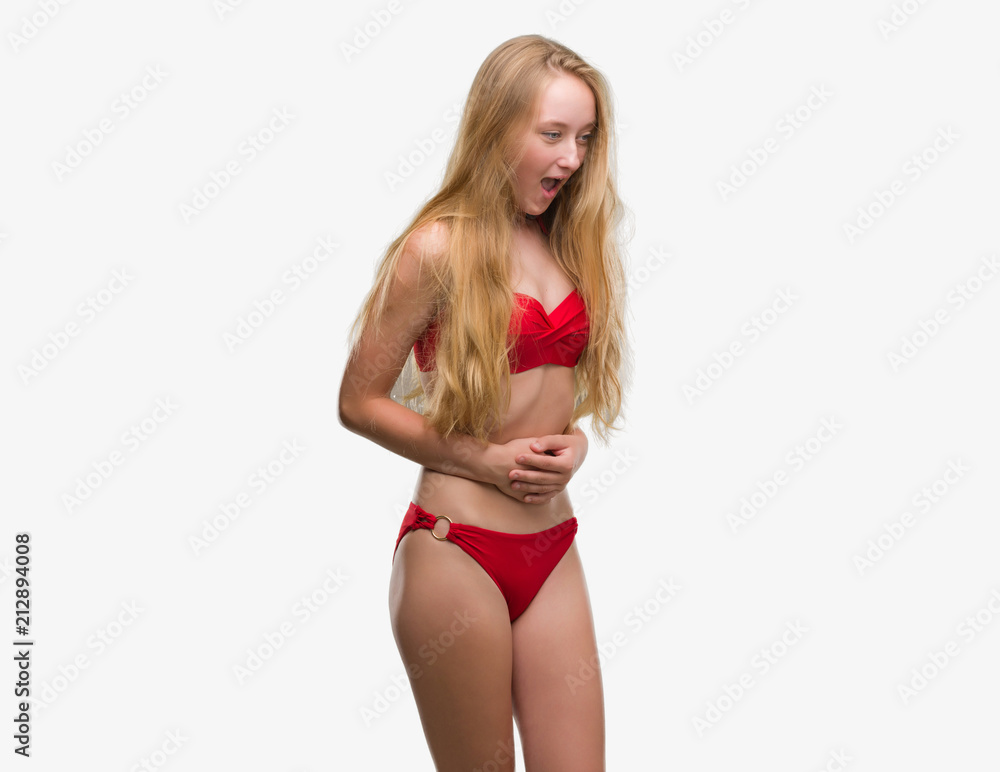 Blonde teenager woman wearing red bikini with hand on stomach because  indigestion, painful illness feeling unwell. Ache concept. Stock Photo |  Adobe Stock