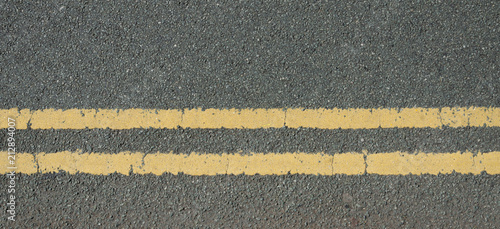 A stone chipping road surface with double yellow lines