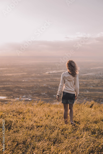 girl looks at the sunset in the mountains