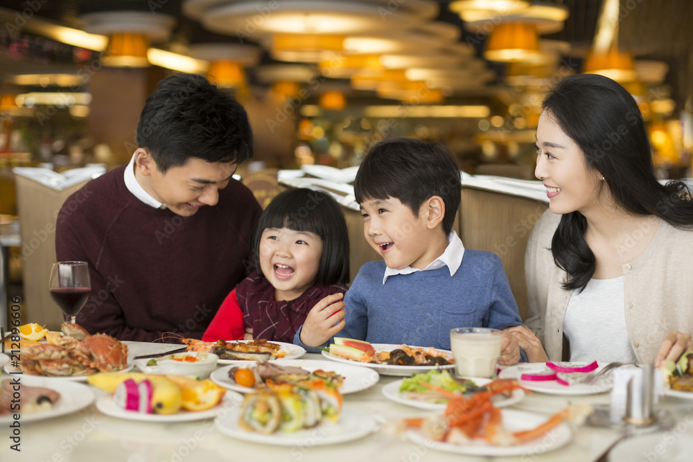 Cheerful young Chinese family having buffet dinner Cheerful young Chinese family having buffet dinner