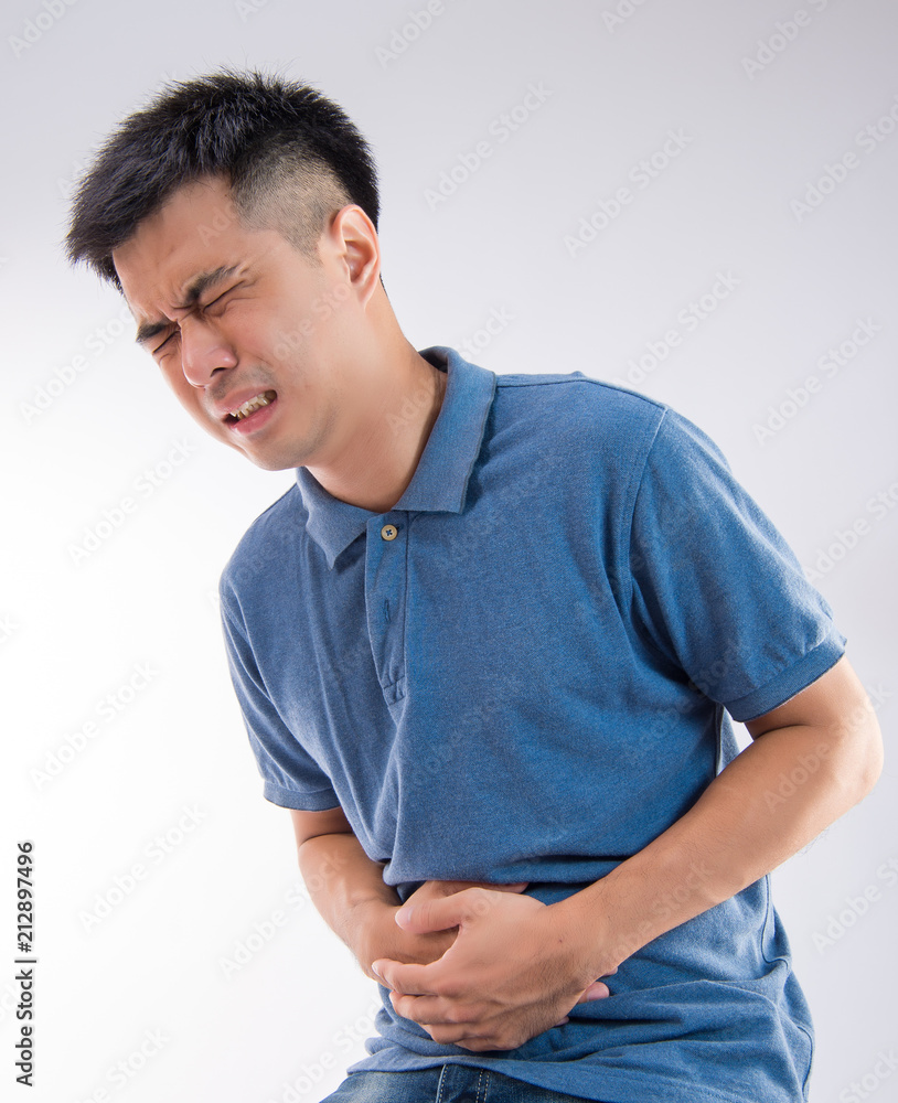 Man putting his hands for belly or stomach ache on white background