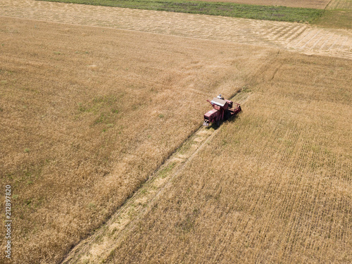 aerial top view to harvested field with tractor