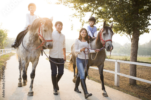 Happy family riding horse outdoors photo