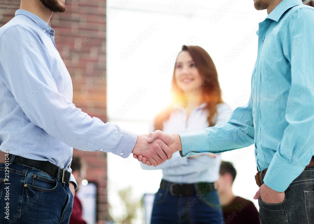 Obraz premium Handshake between businesspeople in a modern office.