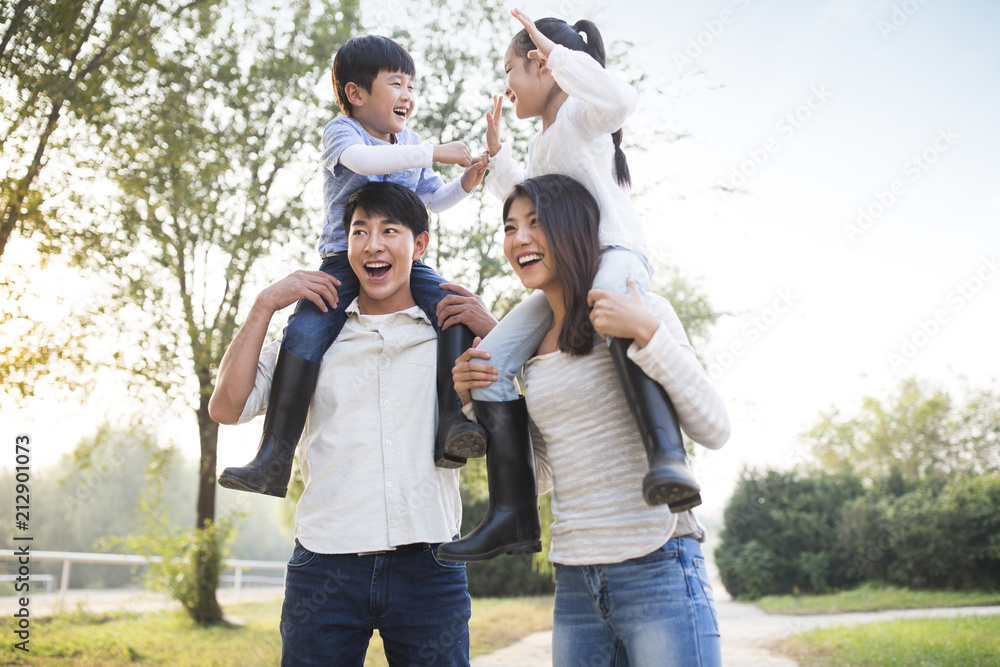 Cheerful young Chinese family playing outdoors Cheerful young Chinese family playing outdoors