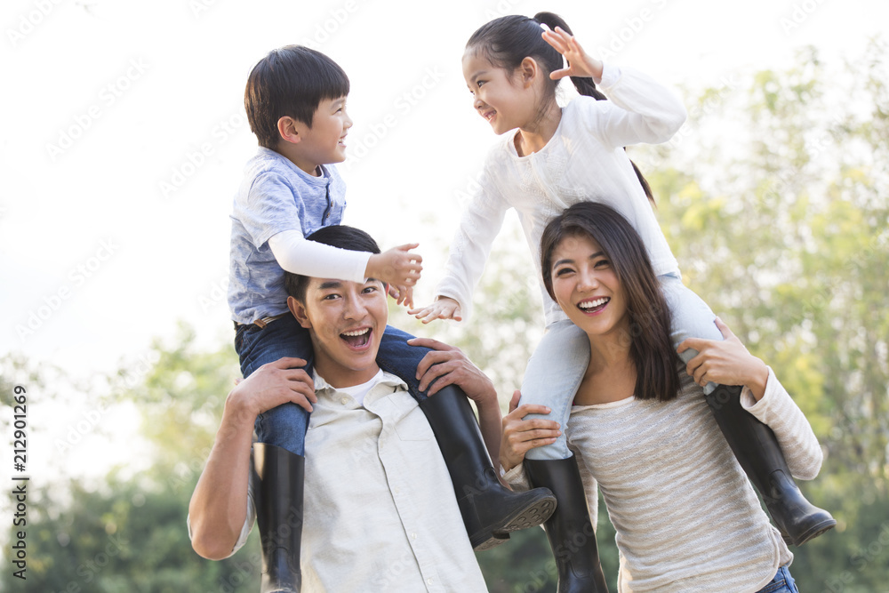 Cheerful young Chinese family playing outdoors Cheerful young Chinese family playing outdoors