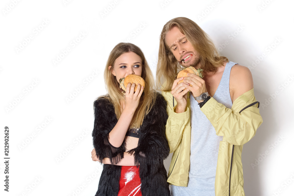 hungry stylish young couple eating tasty burgers on white hungry stylish young couple eating tasty burgers on white