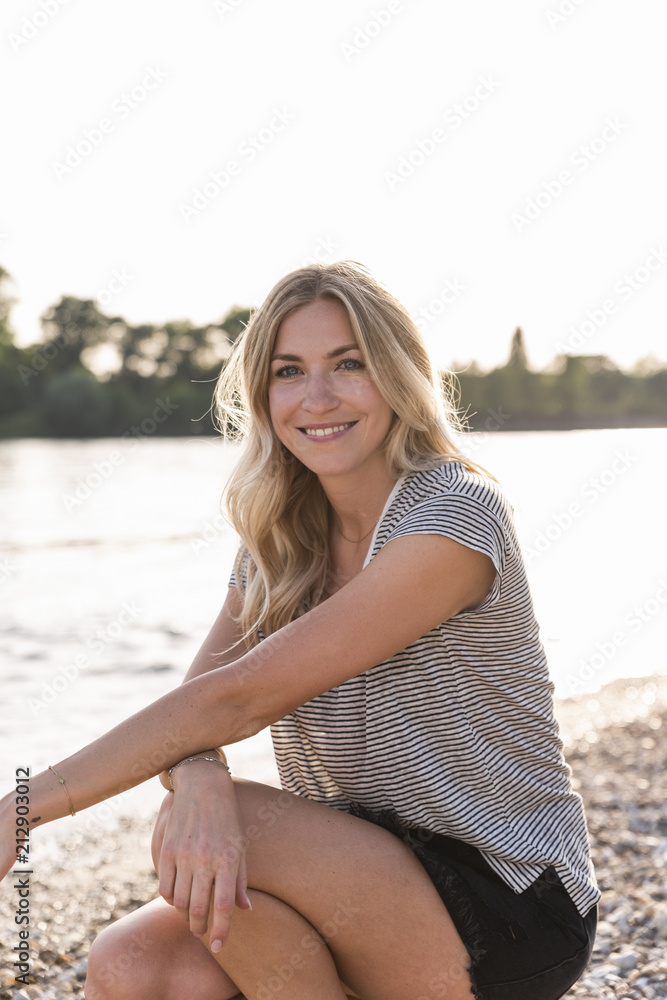 Portrait of blond woman at riverside in the evening Portrait of blond woman at riverside in the evening