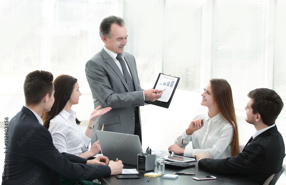 smiling Manager showing a business team ,a graph with financial data.