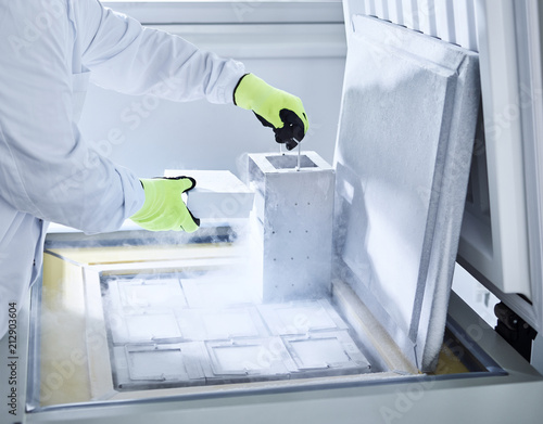 Chemist open upright freezer with gloves
