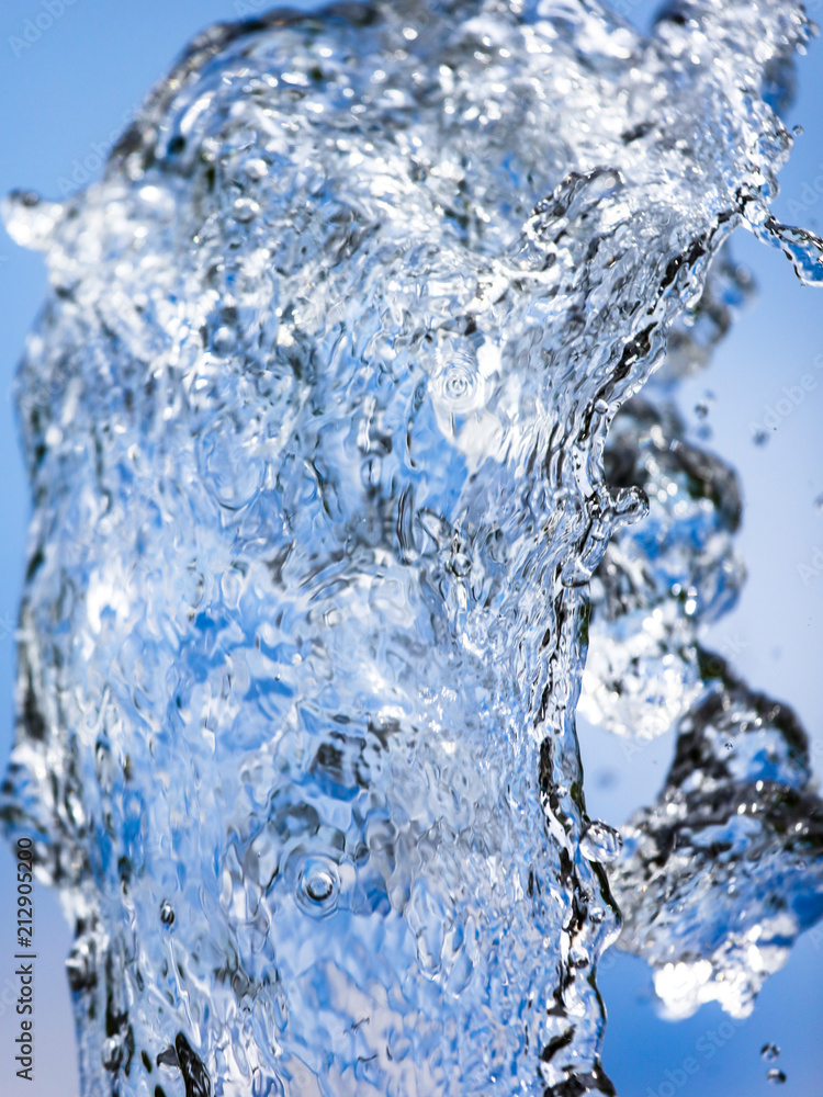 Splashing water with drops on the sky background Splashing water with drops on the sky background