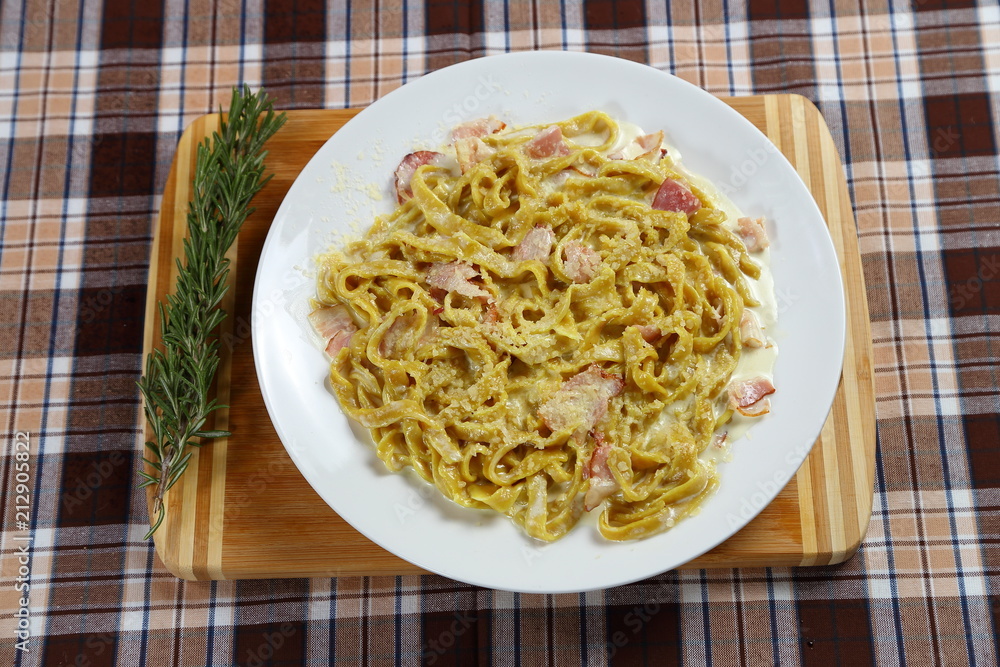 Macaroni of Carbonara with smoked sausage, bacon, sauce. Tasty lunch in the Italian restaurant with herbs, dill
