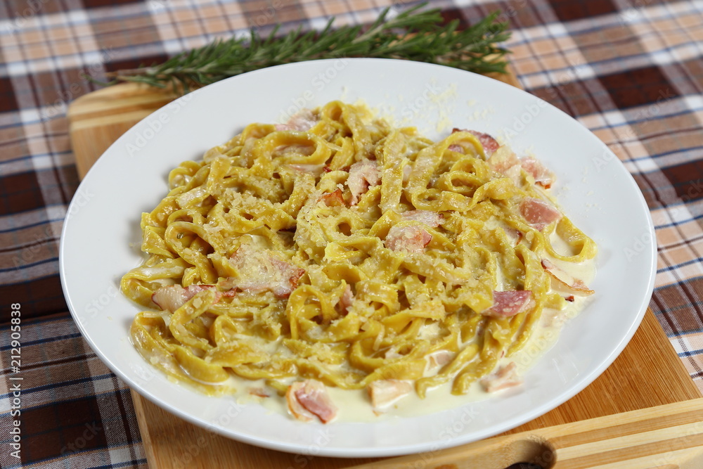 Macaroni of Carbonara with smoked sausage, bacon, sauce. Tasty lunch in the Italian restaurant with herbs, dill Macaroni of Carbonara with smoked sausage, bacon, sauce. Tasty lunch in the Italian restaurant with herbs, dill