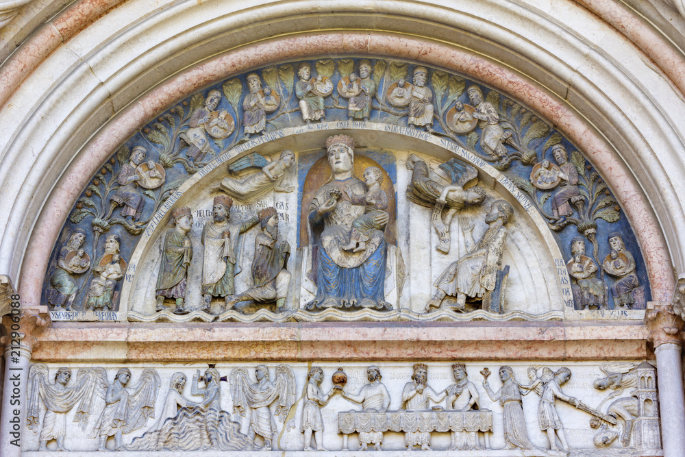PARMA, ITALY - APRIL 17, 2018: The romanesque relief of Madonna with the Child among the Patriarchs and scenes from live of St. John the Baptist on portal of Baptistery by “scultor Benedictus” (1196).