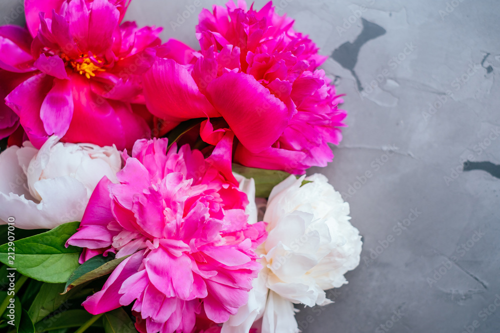 Beautiful fuchsia and white peony flower bouquet on the grey concrete background. Closeup, flatlay style. Beautiful fuchsia and white peony flower bouquet on the grey concrete background. Closeup, flatlay style.