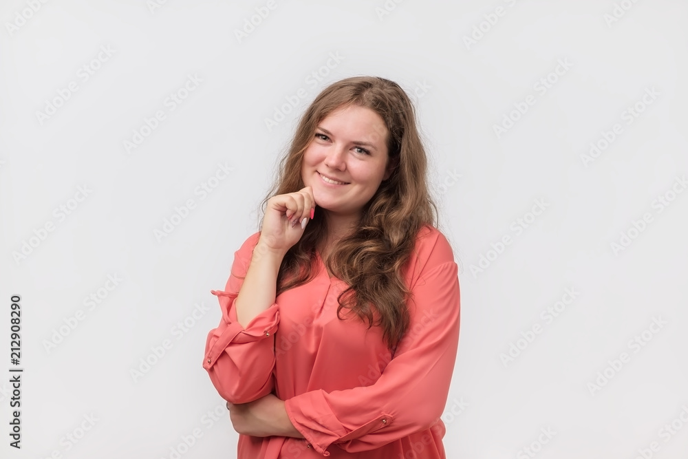 Smiling caucasian plump girl with natural make up in red shirt looking at camera. She is enjoying life. Positive mind and facial emotion Smiling caucasian plump girl with natural make up in red shirt looking at camera. She is enjoying life. Positive mind and facial emotion