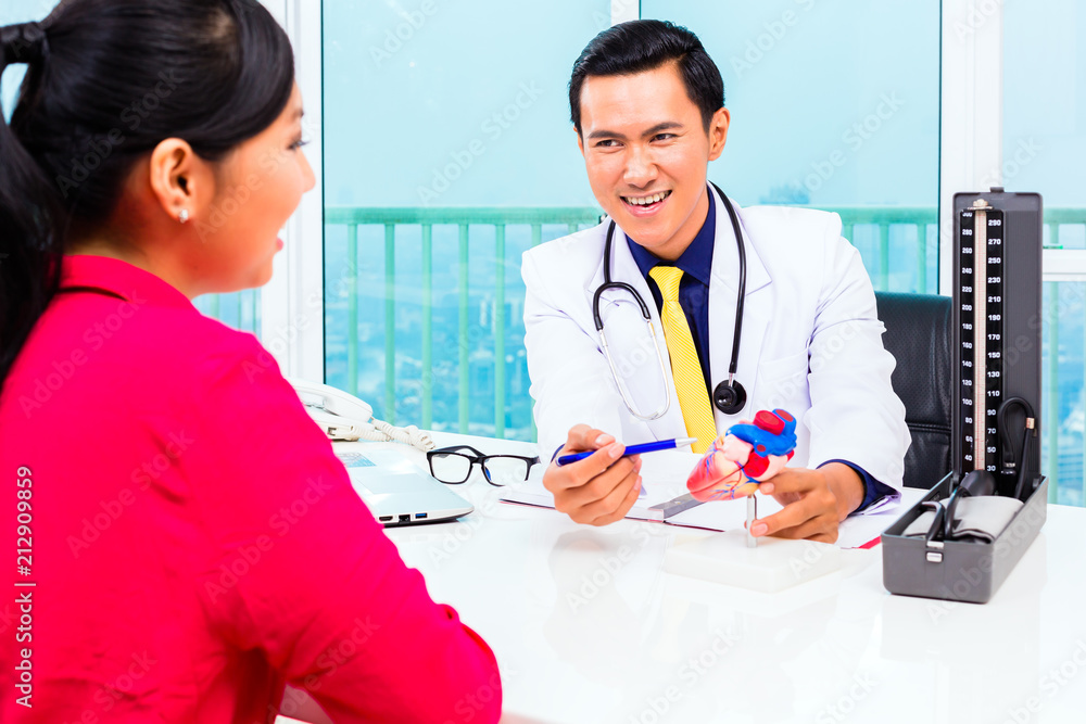 Asian doctor giving patient medical advice in practice or office Asian doctor giving patient medical advice in practice or office