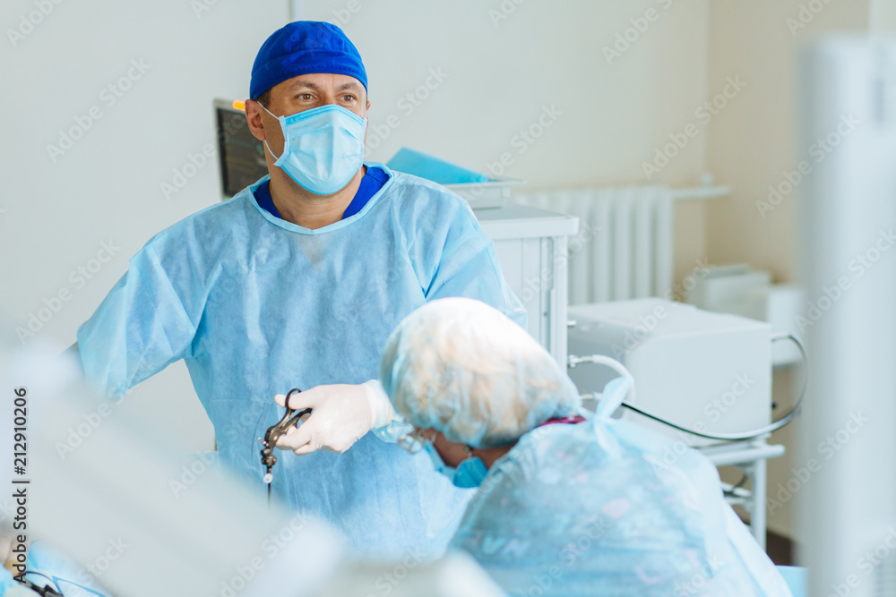 Φωτογραφία Male surgeon preforming operation uterus removal in hospital operating theater, man surgeon operating patient working with surgical laparoscopy instruments