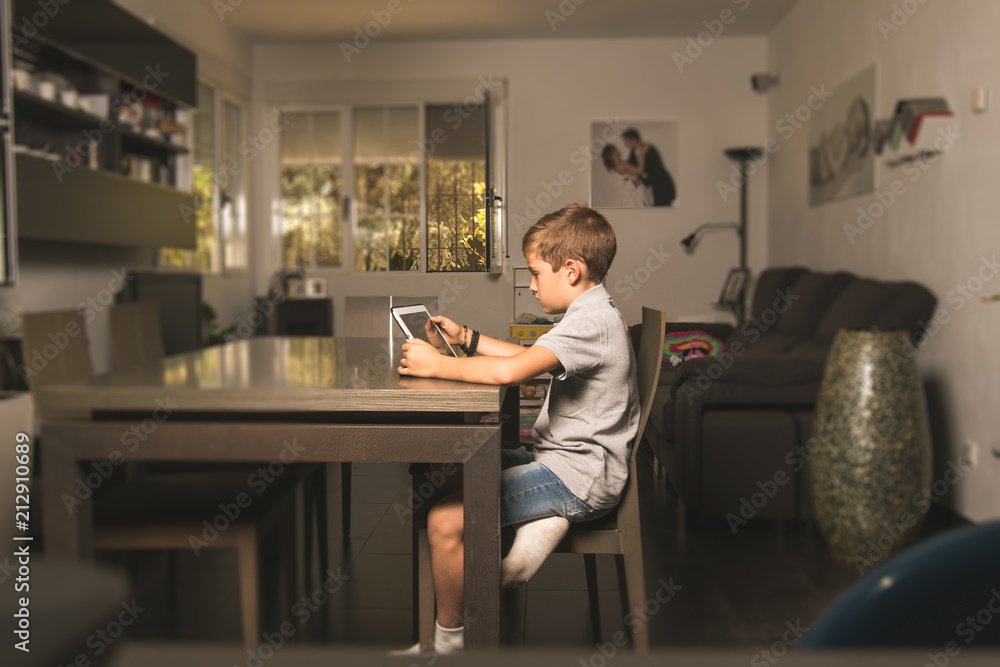 Child watching a tablet at home .Boy looking at a tablet Child watching a tablet at home .Boy looking at a tablet