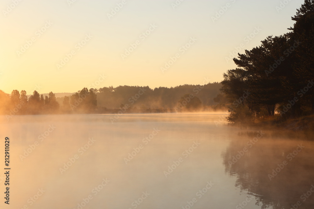 Naklejka premium Sunrise over misty lake