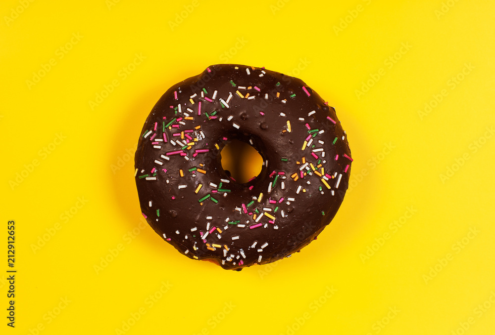 Donuts with chocolate on yellow background Donuts with chocolate on yellow background