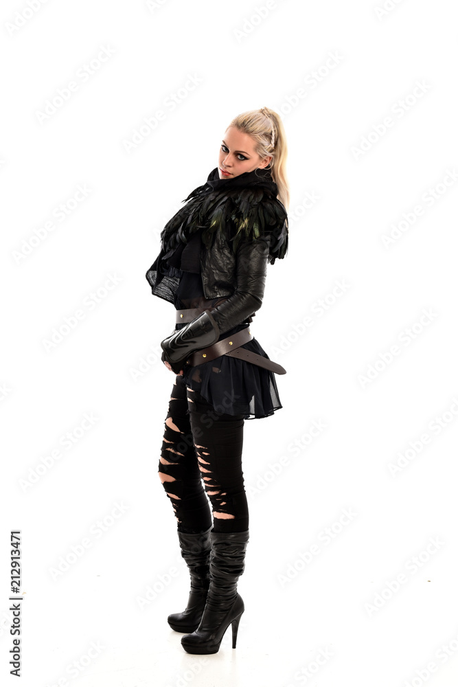 full length portrait of blonde girl wearing lack fantasy warrior outfit. standing pose wit bak to the camera. isolated on white studio background. full length portrait of blonde girl wearing lack fantasy warrior outfit. standing pose wit bak to the camera. isolated on white studio background.
