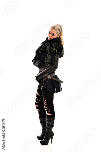 full length portrait of blonde girl wearing lack fantasy warrior outfit. standing pose wit bak to the camera. isolated on white studio background. © faestock