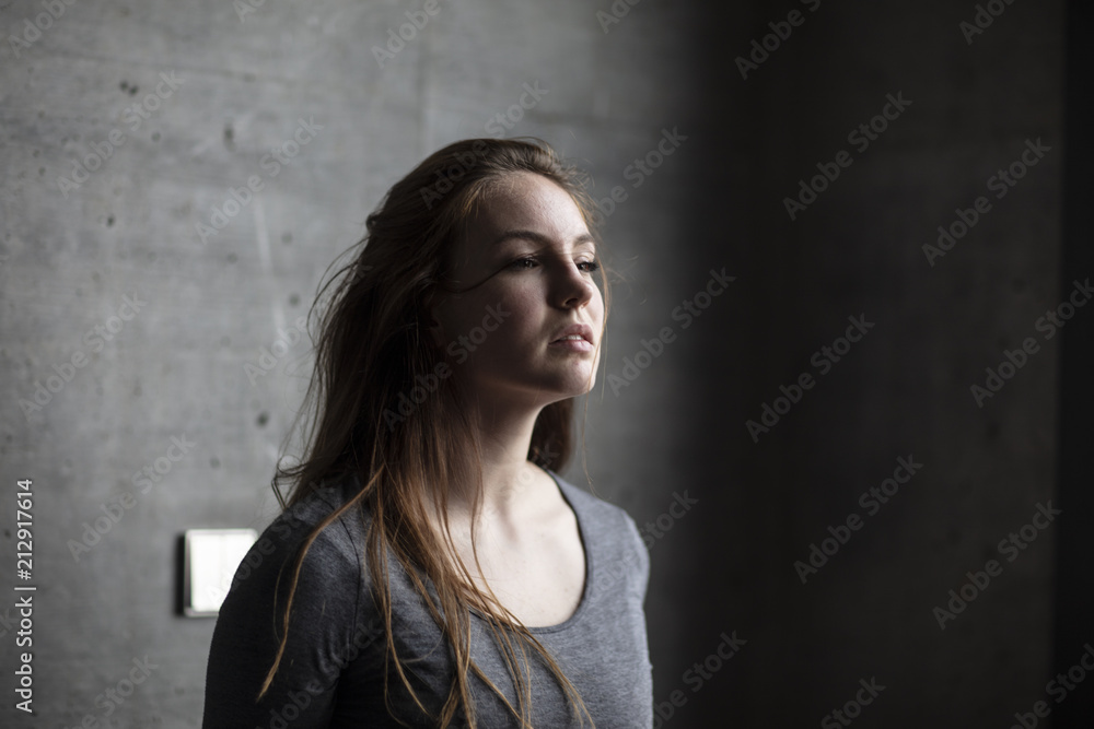 Angled View of Female Model Behind Grey Concrete Wall Angled View of Female Model Behind Grey Concrete Wall