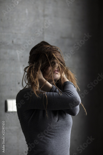 Female Model Posing Behind Grey Concrete Wall