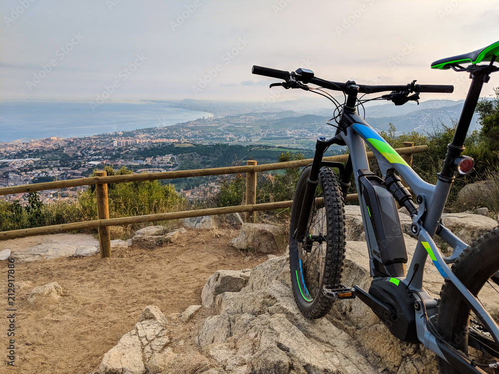 Electric mountain bike standing on top of mountain overlooking the ocean and valley near Barcelona Spain Electric mountain bike standing on top of mountain overlooking the ocean and valley near Barcelona Spain