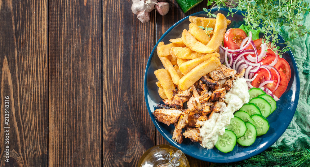 Greek gyros dish with french fries and vegetables