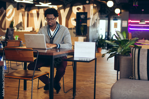 Businessman working on laptop while sitting in office photo