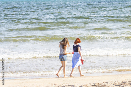 Two ladies walk on the beautiful beach.