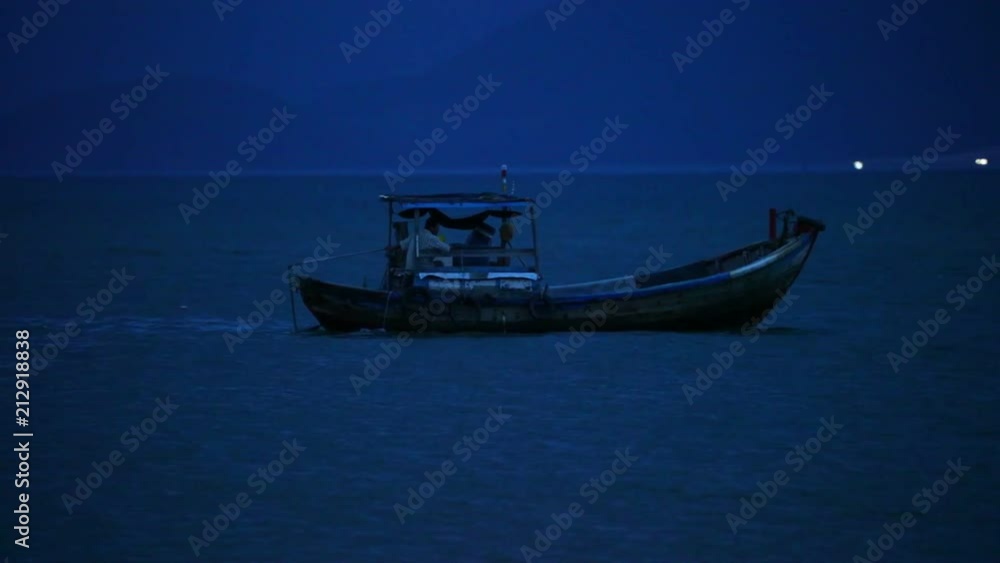 Fisherman in a small wooden fishing boat navigating across the south china sea, night fishing high definition stock footage clip. Fisherman in a small wooden fishing boat navigating across the south china sea, night fishing high definition stock footage clip.
